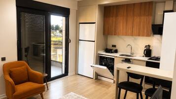 A compact kitchen with a dishwasher, a coffee maker, and a stove.