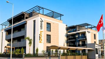 A modern building with a prominent sign for 'Serhan Luxury by Serhan.'