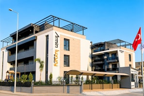 Um edifício moderno com uma placa de destaque para 'Serhan Luxury by Serhan'.
