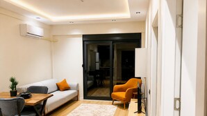 Ein modernes Wohnzimmer mit einer Couch, einem Esstisch und einer TV-Kommode.