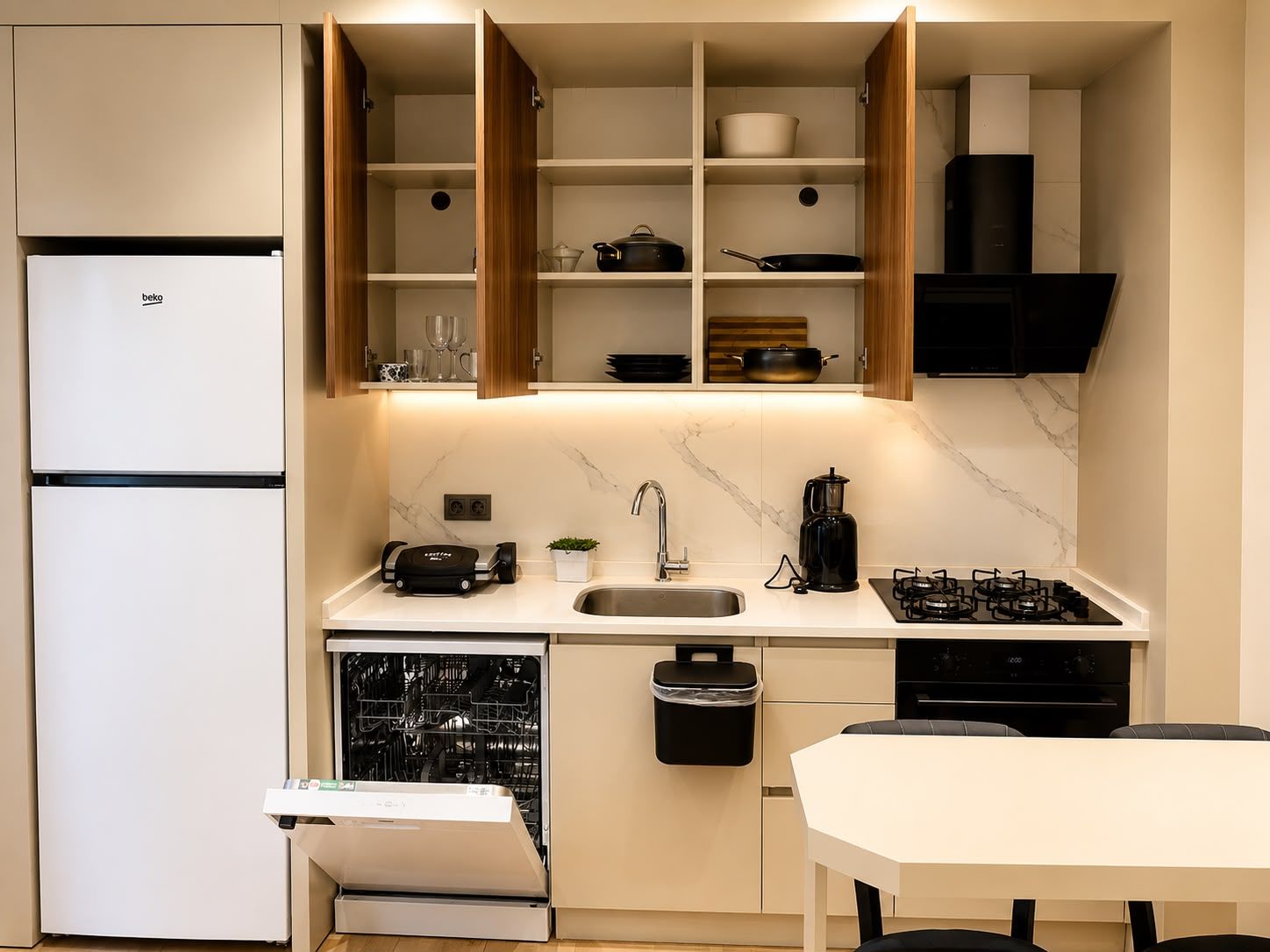 Una cocina moderna con lavavajillas integrado, estufa y refrigerador.
