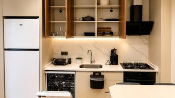 Una cocina moderna con lavavajillas integrado, estufa y refrigerador.
