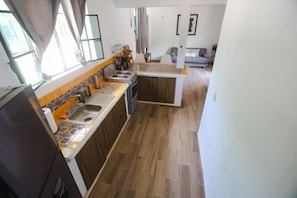 A compact kitchen with a stove, sink, and wooden cabinets.