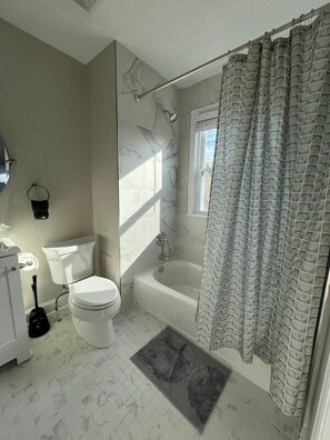 Ein Badezimmer mit Toilette, Badewanne und Duschvorhang.