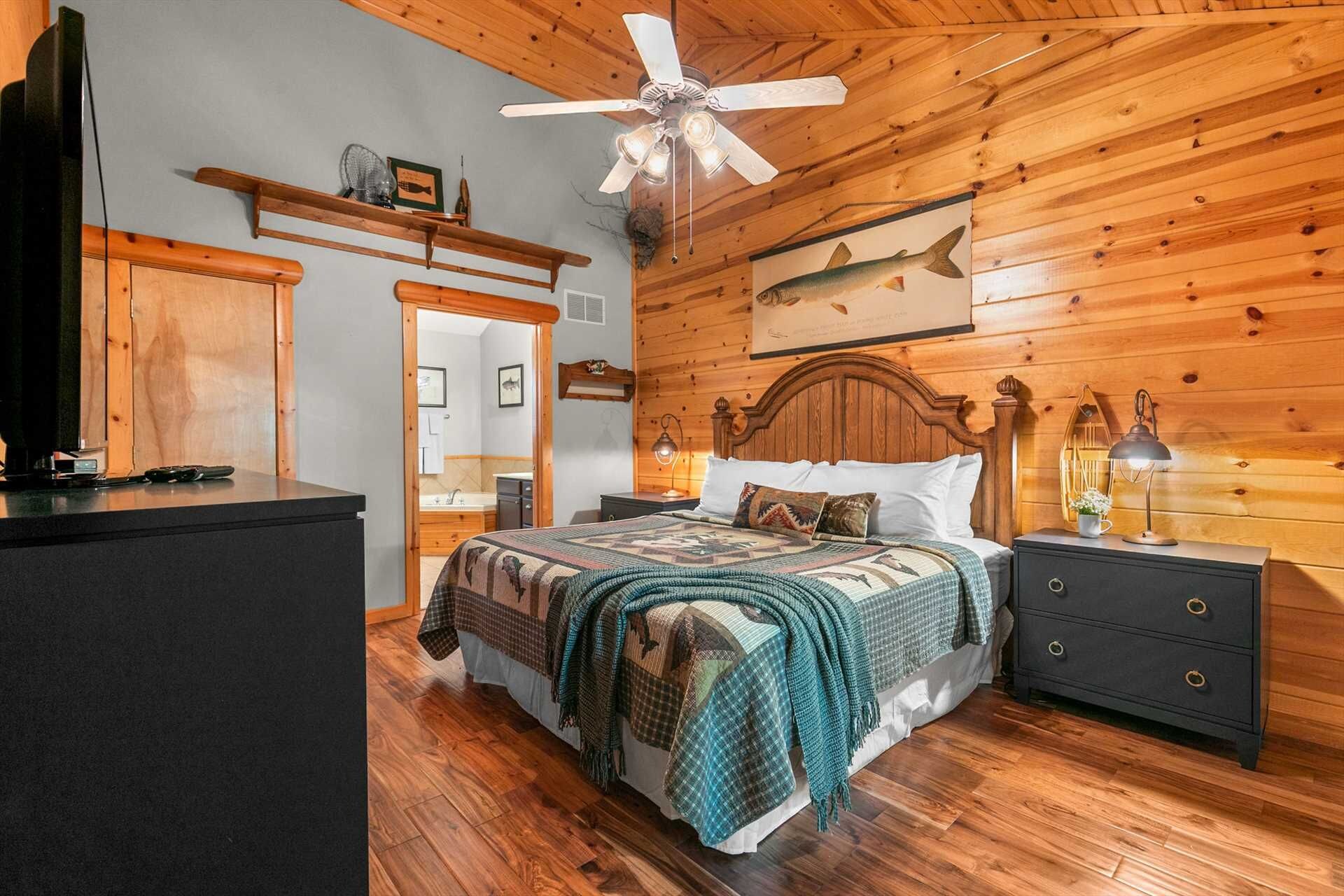 A wooden-paneled bedroom with a bed, nightstands, a ceiling fan, and a fish mural.