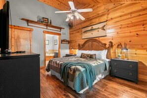 A wooden-paneled bedroom with a bed, nightstands, a ceiling fan, and a fish mural. - Luxury in the Ozarks! 4 Master Suites, 3 Pools, 2 Spacious Living Areas - 19 (Branson)