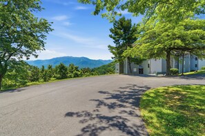 A residential street with a house on the right, surrounded by trees and mountains in the background. - Fantastic 3-bedroom condo in charming Gatlinburg near Ober Gatlinburg (Gatlinburg)