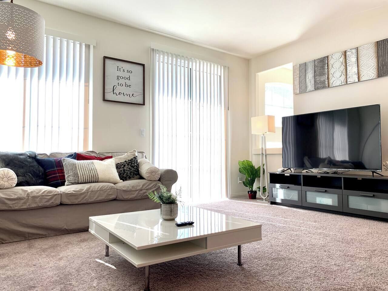 A living room with a sofa, coffee table, TV, and artwork on the wall.