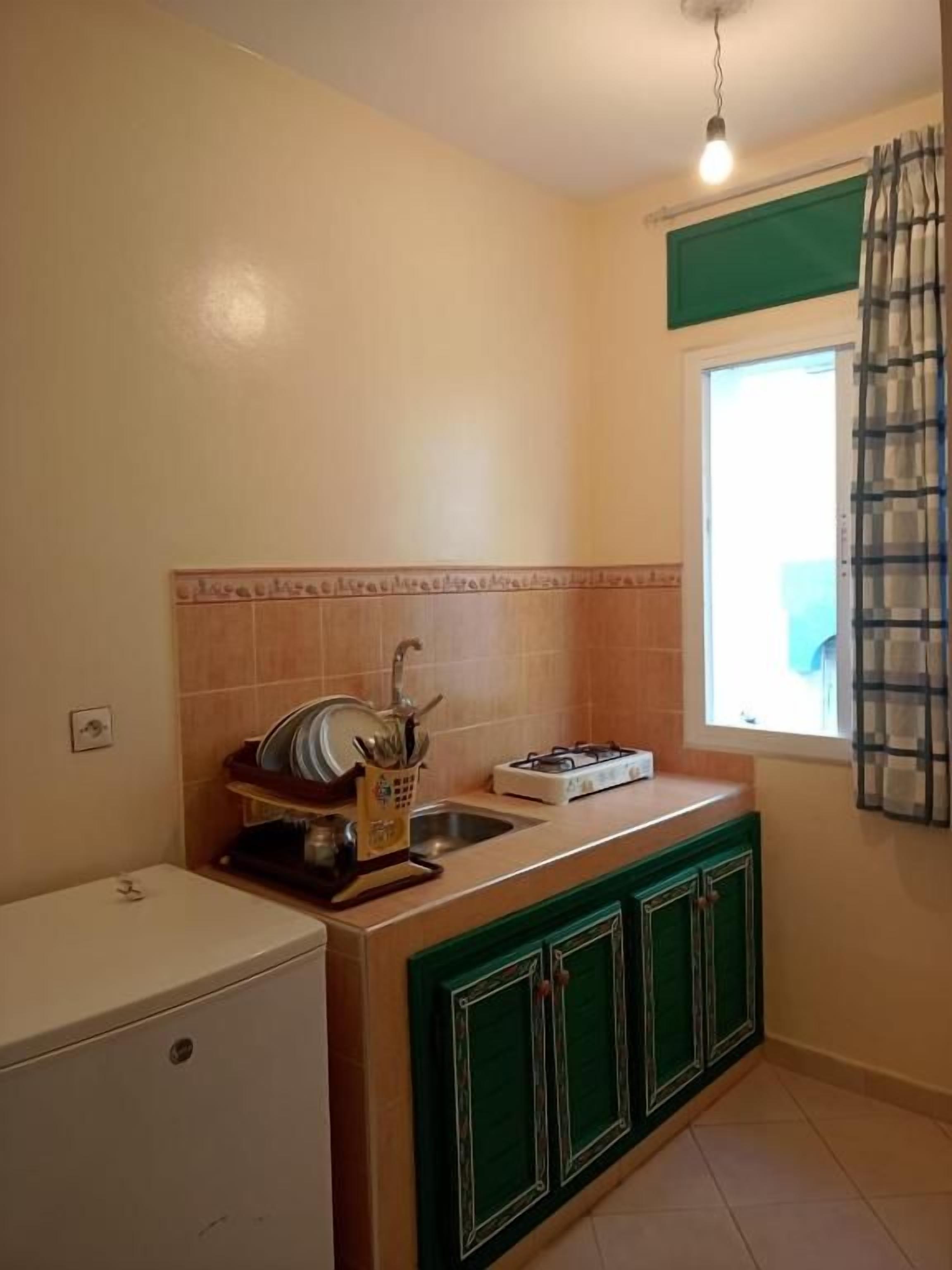 A compact kitchen with a sink, a stove, and cabinets.