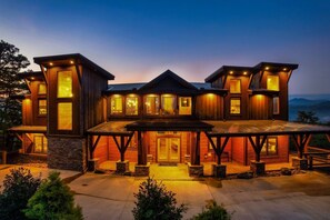 A large, multi-story wooden house with multiple windows and a covered patio area. - Luxury8bdrmCabin-LgPool-HotTub-5MinParkway-Special (Sevierville)