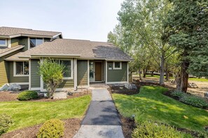 A single-story house with a front porch, a small front yard, and a pathway leading to the entrance.