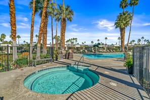 A pool area with two pools, surrounded by palm trees and lounge chairs. - Desert Elegance Off El Paseo (Palm Desert)