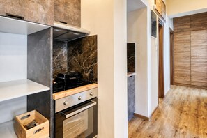 Une cuisine moderne équipée d’une cuisinière, d’un four et d’un meuble en bois.