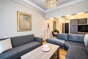Un salon moderne avec des canapés gris, une table basse en bois et un grand miroir.