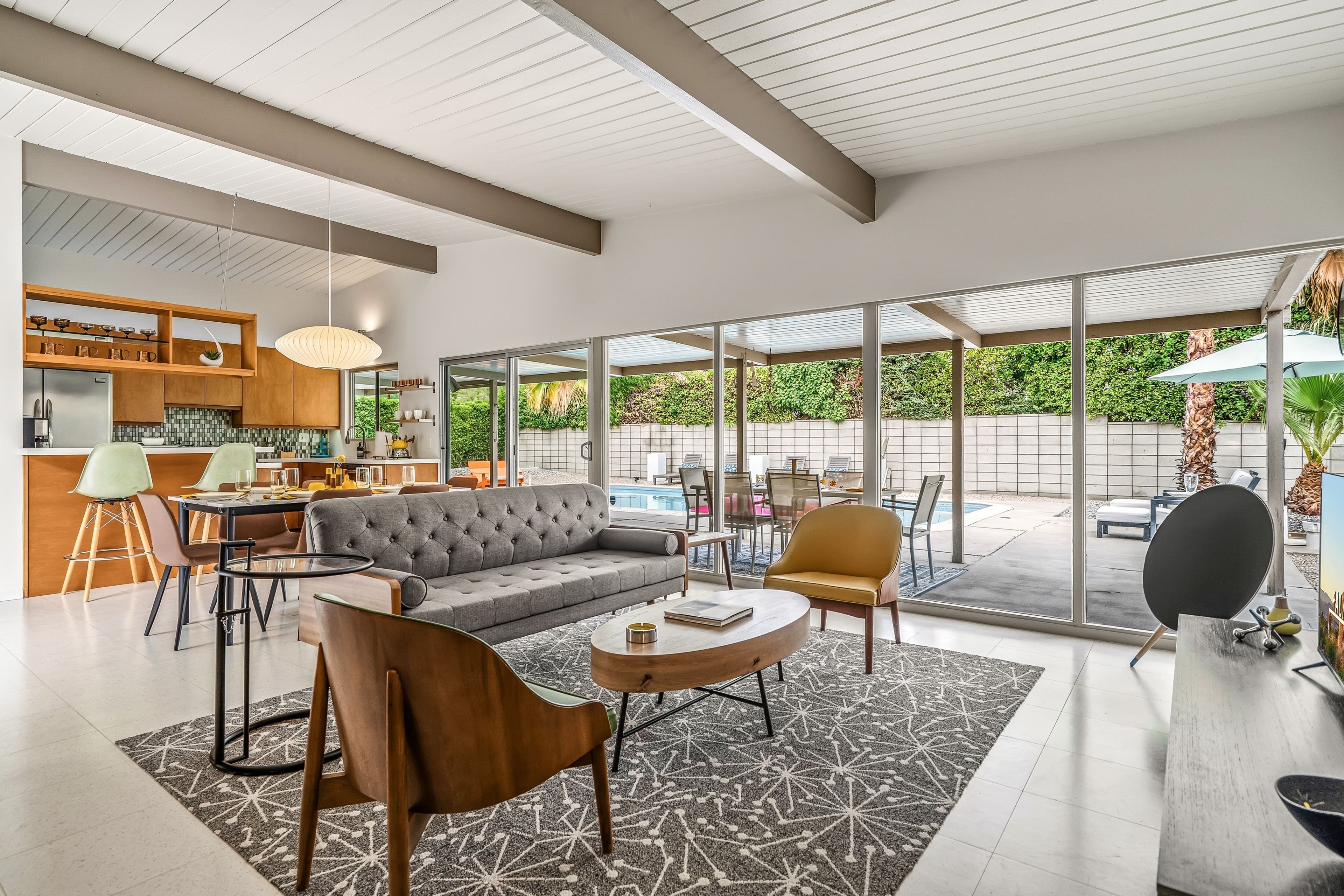 A modern interior with a sofa, chairs, a dining area, and a kitchen.