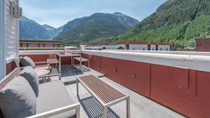 A rooftop terrace with outdoor seating, a table, and a view of mountains. - Diamondtooth 3 3 Bedroom/ 3 Bathroom Downlown Condo (Telluride)