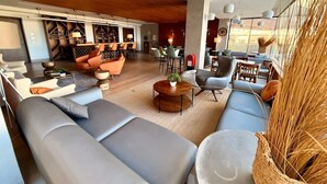En moderne stue med sofaer, et sofabord og et spiseområde med stole og bord.