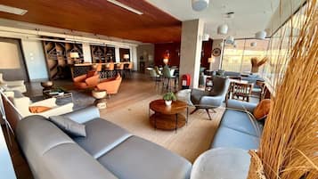 Un salon moderne avec des canapés, une table basse et un coin repas comprenant des chaises et une table.