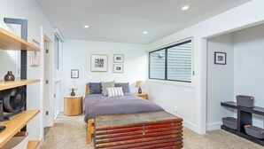 A bedroom with a bed, bedside tables, a fan, and a window. - Telluride Lodge Condo 323 (Telluride)