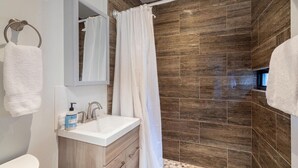 A bathroom with a shower, a sink, and a mirror. - Telluride Lodge Condo 323 (Telluride)