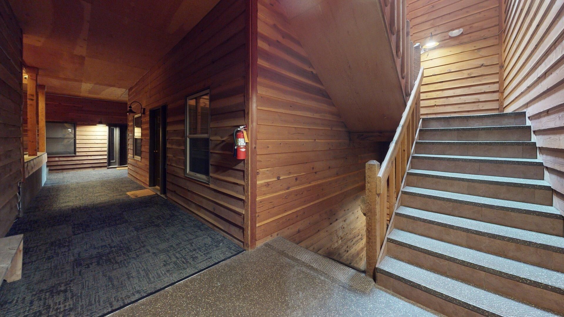 A wooden interior with a staircase and a fire extinguisher.