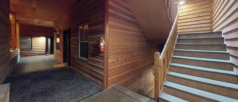 A wooden interior with a staircase and a fire extinguisher.