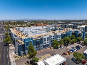 A multi-story building with a flat roof, parking lot, and a clear sky. - Bright Tempe Studio • Green Views • 5 Min to A (Tempe)
