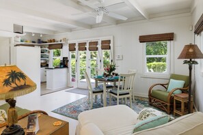 A spacious room with a dining area, a sofa, a chair, and a lamp. - Mele Mele  3BR Puako Beach Retreat Steps to Ocean Access (Waimea)