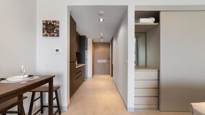 A modern kitchen with wooden cabinets and a dining area with a table and chairs. - Two 1001A Studio -Stylish Beachfront studio with Stunning Ocean Views (Puerto Peñasco)
