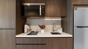 A modern kitchen with a stainless steel microwave, a sink, and a refrigerator. - Two 1001A Studio -Stylish Beachfront studio with Stunning Ocean Views (Puerto Peñasco)