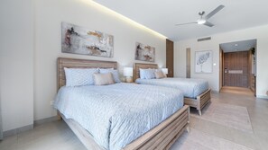 A modern bedroom with two beds, wooden headboards, and abstract wall art. - Two 406A Hotel Room : Sunrise Over Cortez (Puerto Peñasco)