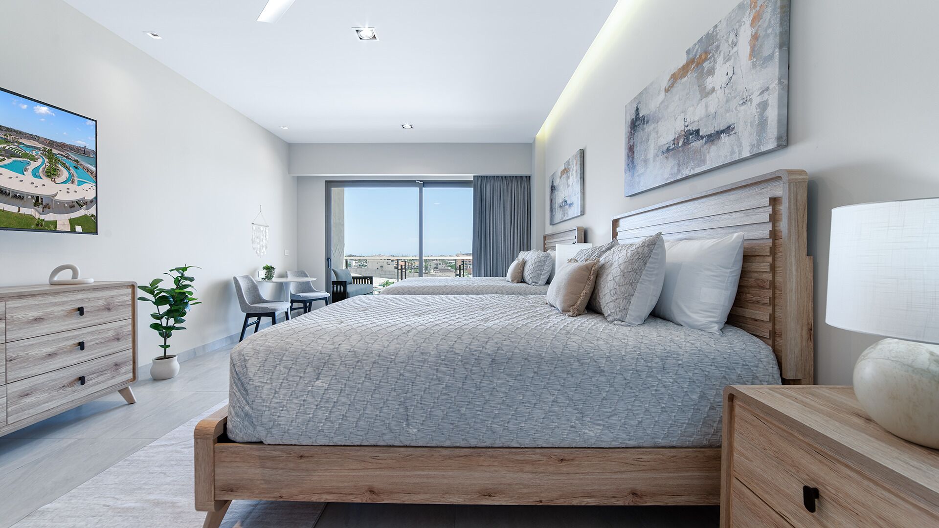 Une chambre moderne avec un grand lit, un bureau et une vue sur la ville.