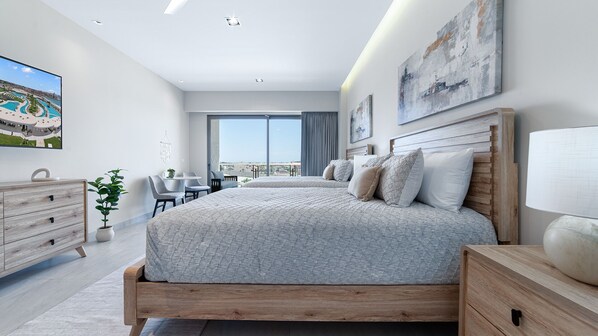 A modern bedroom with a large bed, a desk, and a view of the city. - Two 406A Hotel Room : Sunrise Over Cortez (Puerto Peñasco)