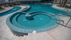 A swimming pool with a circular design, surrounded by lounge chairs and a manhole cover. - Two 406A Hotel Room : Sunrise Over Cortez (Puerto Peñasco)