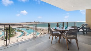 A balcony with a view of a beach and a pool complex. - Two 406 - Sea Luxe 1 bedroom condo (Puerto Peñasco)