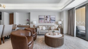 Uma sala de estar moderna com sofá, cadeiras, mesa de centro e obras de arte na parede.