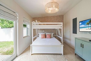 A bunk bed room with a ceiling light fixture and a television on the wall. - Latitude Adjustment by SeaBreeze Vacation (Holmes Beach)