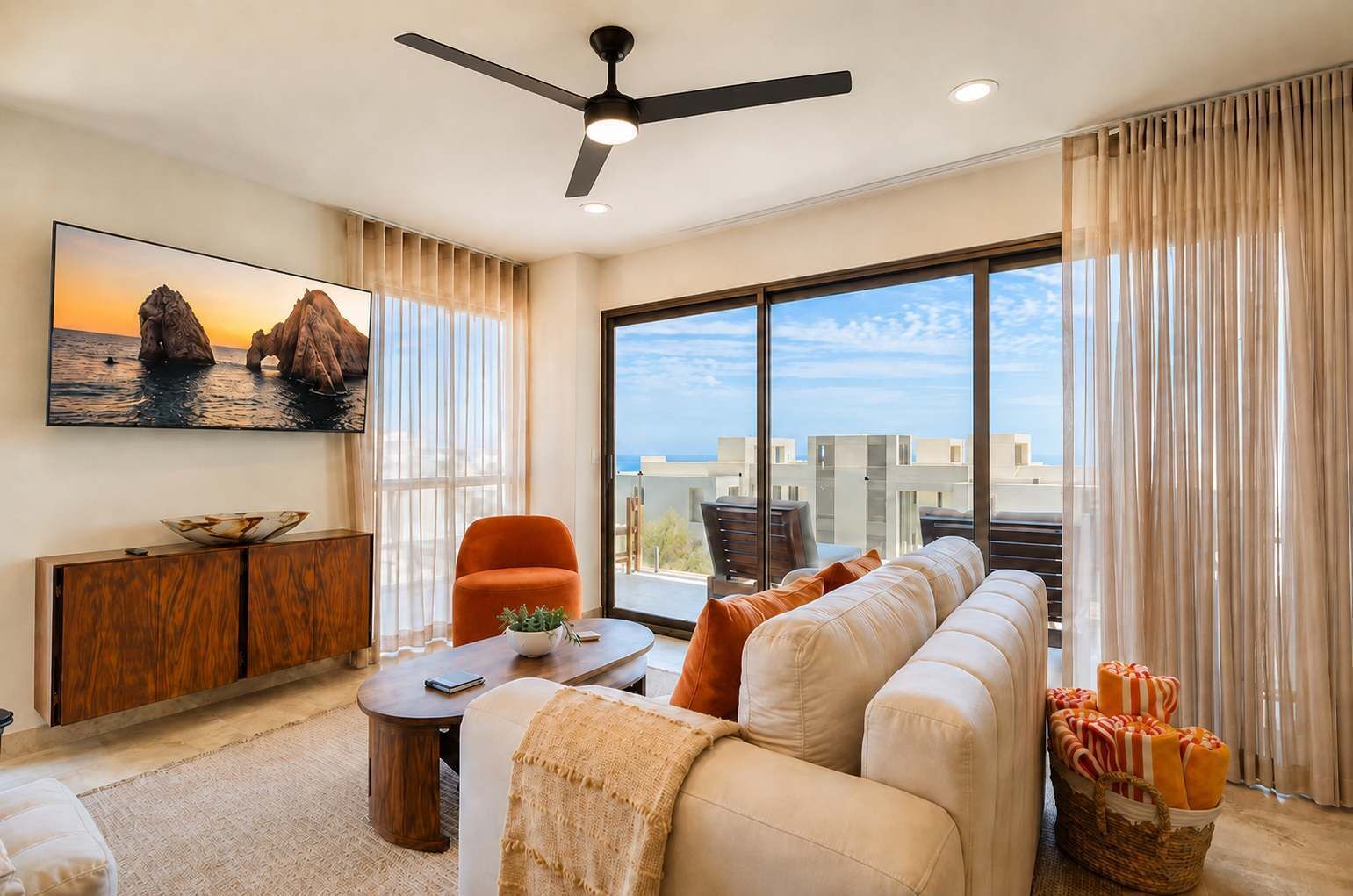 Una sala moderna con un sofá, una mesa de comedor, una silla y un amplio ventanal con vistas a edificios y al cielo.