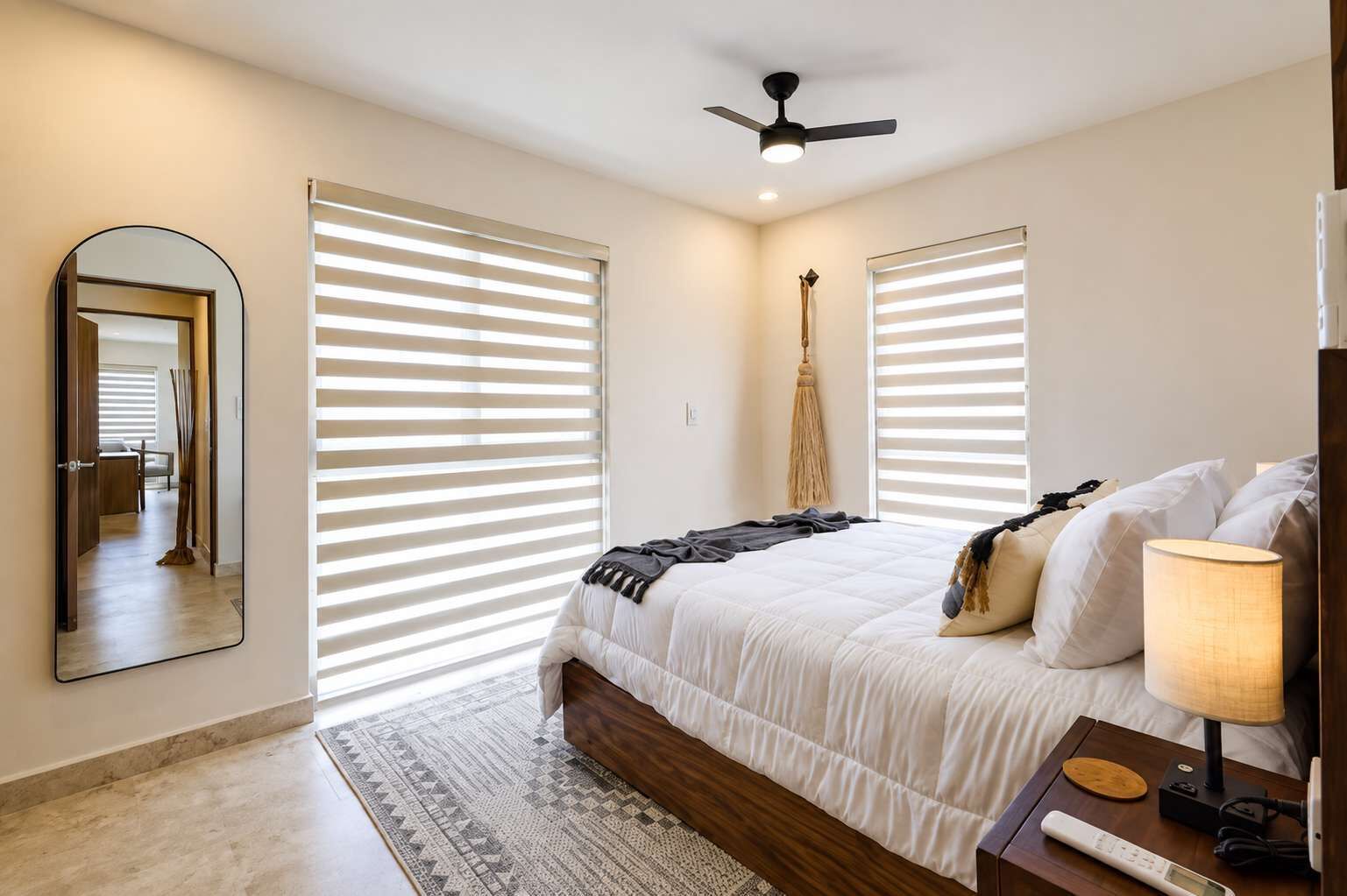Une chambre à coucher avec un lit, une lampe de chevet et un ventilateur de plafond.