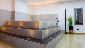 Zona de recepción con diseño moderno, que incluye un mostrador de recepción, una escalera y una planta en maceta.