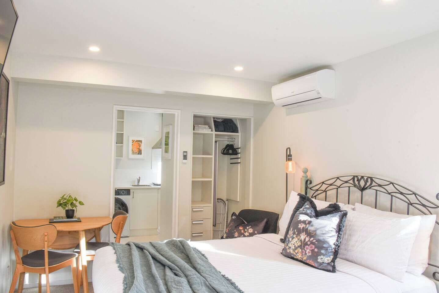 Une chambre à coucher comprenant un lit, un bureau, une chaise, une armoire et un appareil de climatisation.