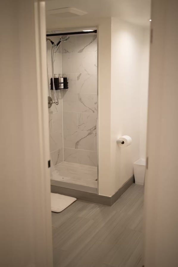 A modern bathroom with a shower, toilet, and a towel on the floor. - Spacious 3-bedroom house in peaceful Clovis with AC (Clovis)