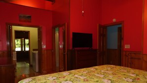 Una stanza con un letto, una televisione e porte in legno.