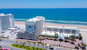 Un hôtel situé sur la côte, composé de plusieurs bâtiments, doté d’un parking et offrant une vue sur la plage.