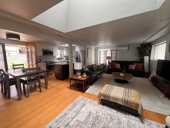 A spacious living area with a dining table, sofa, and a kitchen in the background. - Peaceful Retreat near Airport & Downtown Seattle (Seattle)