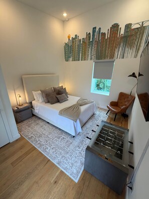 Un dormitorio moderno con cama, ventana, sofá y mesa de futbolín.