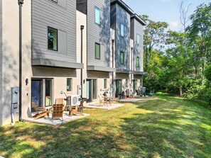 A modern multi-story residential building with a covered outdoor seating area.