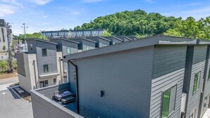 Un immeuble résidentiel moderne à plusieurs étages, doté d’un toit plat, de grandes fenêtres et d’un espace de stationnement.