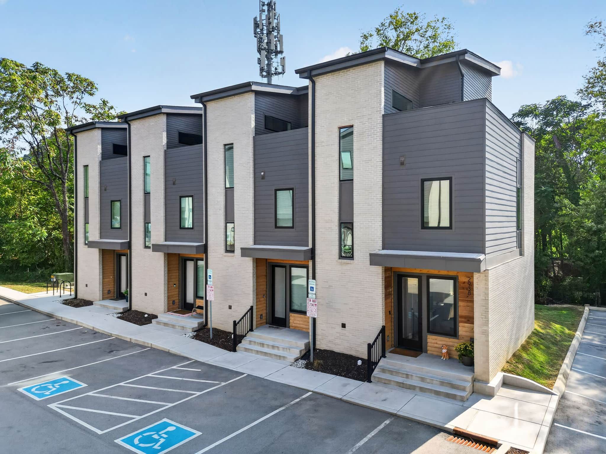 Un immeuble moderne à plusieurs étages, avec un parking situé à l’avant.