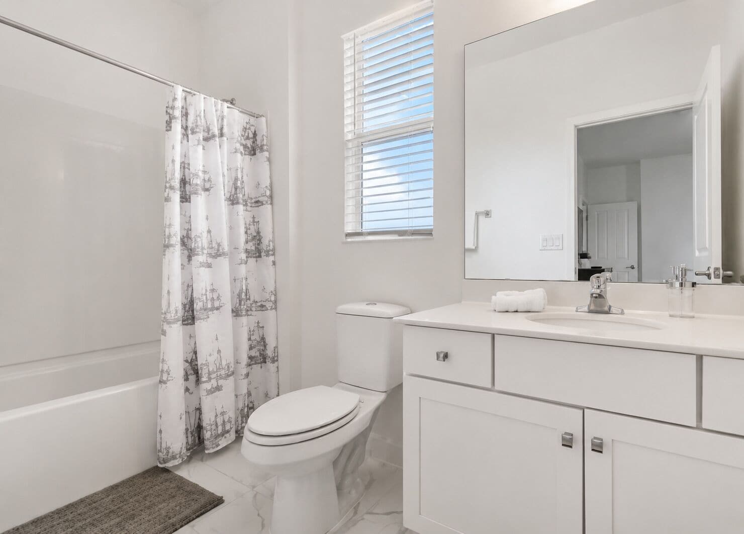 Un baño moderno con inodoro, lavamanos y cortina de ducha.